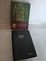 Photo showing front of Bible box with detailed text and Bible cover with gold embossed text and name.