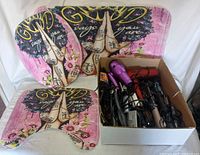 Photo showing four decorative bathroom mats with an artistic hair care design and a box containing hair dryers and hair styling tools.