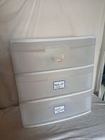 Front view of the white plastic 3-drawer rolling storage cabinet showing labeled drawers and translucent drawer fronts.