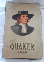 Front of original packaging showing portrait and Quaker Lace branding.
