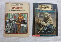 Photo showing the covers of two Star Wars activity books: 'Return of the Jedi Spelling A Grade 1 Workbook' with R2-D2 and C-3PO on the cover and 'The Empire Strikes Back Pull-Out Poster Book' with Yoda on the cover.