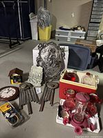 Photo showing overall lot with hummingbird feeder, suet feeder, metal wall art, wind chimes, decorative plaques, and bungee cord pack