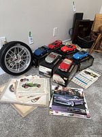 View of six special edition Maisto diecast model cars with boxes, various vintage car art prints, and old calendars