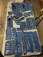 Full assortment of flatware, fabric holders and accessories laid out on table