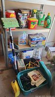 Photo of metal shelving with various garden and automotive chemicals and supplies including fertilizers, insecticides, sprays, a mop, and totes.