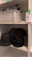 Shelf with multiple men's wool hats and some accessories