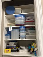Shelves filled with a wide variety of plastic food storage containers stacked with lids, foil trays, and food wraps at the bottom shelf.