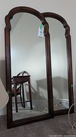 Full view of both matching wall mirrors standing side by side, showing the entire frame and mirror size.