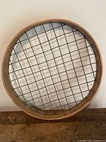 Top view of the circular wooden frame sifter showing rawhide cord grid.