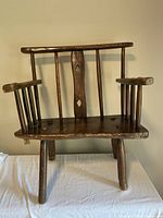 Front view of antique rustic oak shepherds chair showing seat, legs, and armrests
