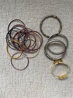 Colorful thin bangles with metallic finish and three silver-tone bangles plus translucent bracelet with gold accents