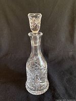 Full view of clear crystal decanter with stopper, showing cut glass pattern