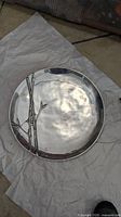 Large round metal platter with hammered finish, decorative bamboo motif on surface