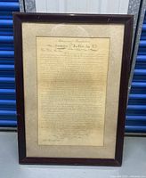 Full view of framed antique letter against storage background showing frame and aged paper.