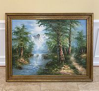 Front view of large framed landscape painting showing river, trees, waterfall, and mountains.