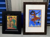 Two framed art prints side by side, one with abstract portrait and the other with text and dancing figure.