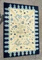 Full view of rectangular Native American tribal style rug with geometric patterns and border showing all signs of wear and colors