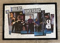 Full view of the framed poster of The Fabulous Thunderbirds band with all members and band name visible.