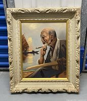 Framed vintage oil painting of an elderly Asian man with a pipe and wooden oar, set against a maritime background with sailboats at sunset or sunrise.