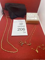 All items displayed on red backdrop alongside black pouch and box