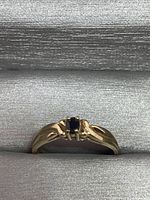 Front view of ring showing square-cut blue stone and band design