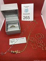 Overview of ring, chains and hoop earrings on red background