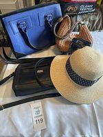 Full view of all items including blue purse, brown straw purse, black purse, and beige hat