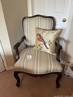 Photo of Ashley Furniture accent chair with striped upholstery and a bird pillow on the seat, showing front view.
