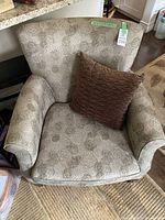 Chair base and backrest showing floral upholstery pattern, label and green tape with lot number