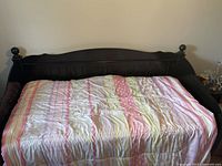 Full front view of dark wood Ashley Jaidyn daybed with bedding on it