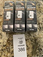Three sealed boxes of Rayhong Car Scratch Removal Wax, each 120ml, placed on a granite countertop next to auction tag number 386.