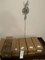 View of all five boxed metal fairy garden decorations, unopened in original packaging.