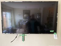 Front view of TV mounted on wall showing screen and bezel