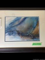Framed abstract watercolor art by Lorraine McDonald showing full view of white and blue matted frame and abstract watercolor in blues and browns.