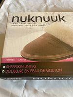 Closed box showing Nuknuuk brand, ladies' leather slippers with sheepskin lining.