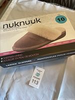 Photo of the closed box featuring a product image of a dusty mauve Nuknuuk ladies' leather slipper with sheepskin lining size 10