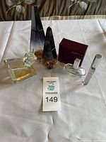 Full view of all five perfume bottles including two tall and one small Givenchy Ange ou Demon bottles, Calvin Klein Euphoria bottle and travel size, and one small clear spray bottle.