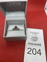 Ring displayed in Peoples branded jewelry box with auction lot card visible