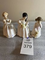 Three Royal Doulton porcelain figurines displayed together on a flat surface: Catherine, Mandy, and Daddy's Girl.