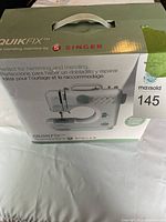 Front of Singer QuikFix box showing branding, model, and use case for hemming and mending.