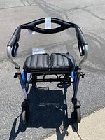 Front view of the blue walker showing the padded seat and frame structure.