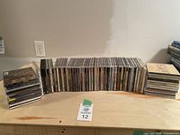 A wide shot of about 70-80 CDs arranged standing upright, showing their spines with artist and album names visible.