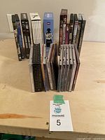 Front view of all CDs and DVDs arranged on a table shown in groups with jewel cases and standard DVD cases.