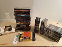 Wide view displaying three groups of DVDs: stack of assorted movies and TV series, boxed coexistence of Sherlock, Endeavour, and DCI Banks, and separate collections of Inspector Lewis and George Gently DVDs.