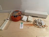 Overview of all items on the table including extension cords, power strips and adapters.