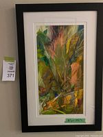 Framed abstract wall art showing colorful organic shapes and brush strokes, mounted on wall with visible measurement tape on green tape indicating size 16" x 24.5"