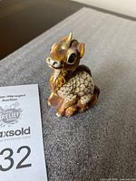 Side view of the Windstone Editions Ki Rin Child Unicorn figurine showing scale texture and face.