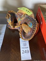 Overall view of curled dragon figurine displaying color and scale details