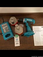 Complete lot showing Makita cordless drill, two batteries, charger, and manual.