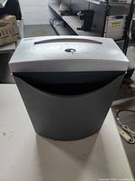 Front view of the Aurora paper shredder showing overall shape and size with black base and silver top